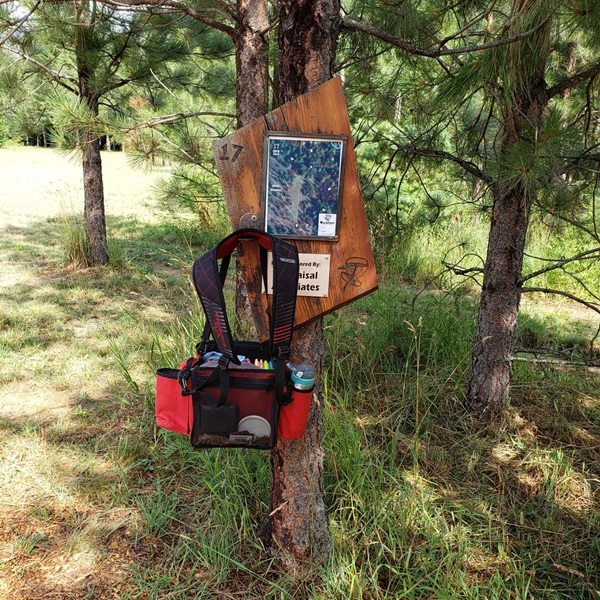 The course is located within a picturesque wooded area, providing players with a tranquil setting for a round of disc golf. 