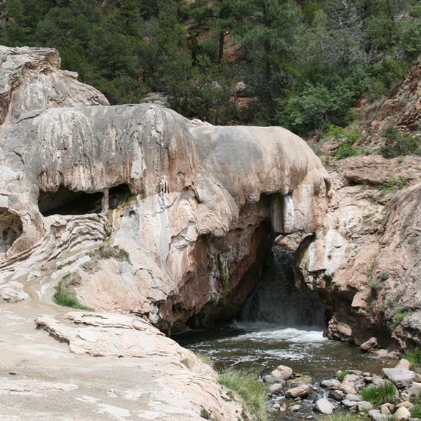 Soda Dam is a natural bridge over the Jemez River formed by thousands of years of calcium carbonate and travertine deposits from a hot spring. 