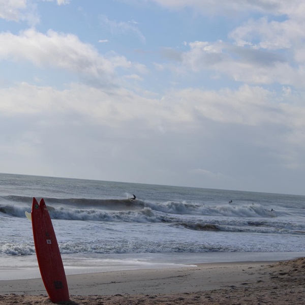 The beach break produces both left and right waves, and conditions can vary depending on the tide and swell direction. 